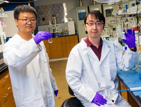 Rice University postdoctoral fellow Zhen-Yu Wu, left, and graduate student Feng-Yang Chen show the products of their high-performance nanowire catalyst, which has the ability to pull ammonia and solid ammonia (fertilizer) from nitrate, a common contaminant in industrial wastewater and polluted groundwater. (Credit: Jeff Fitlow/Rice University)