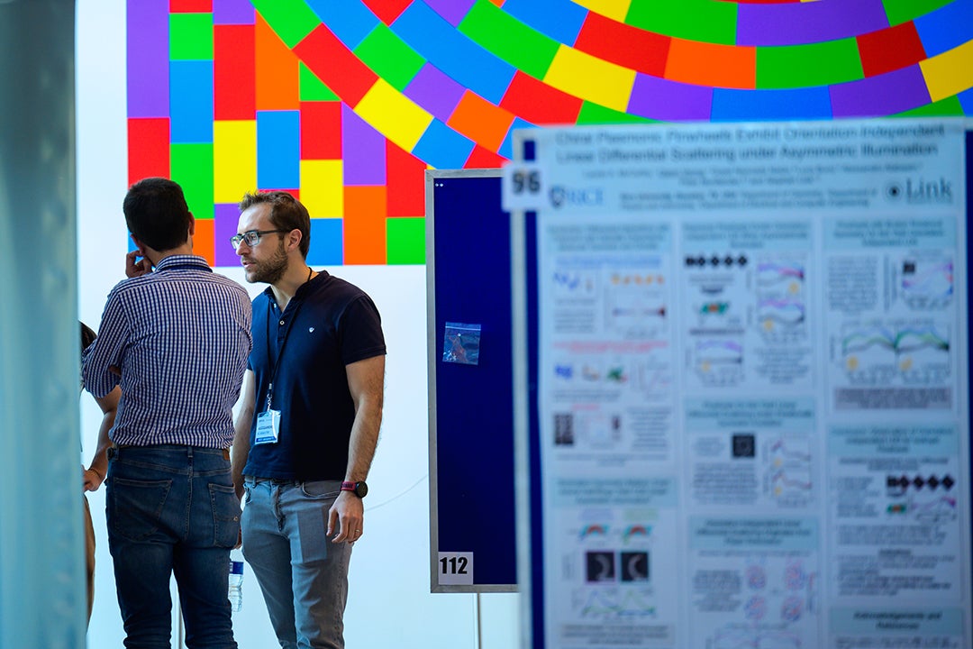 Rice Assistant Professor of Electrical and Computer Engineering Alessandro Alabastri (right) speaks with an SPP10 poster presenter during a May 25 session break