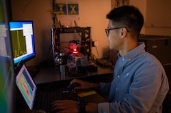 Graduate student Wei Meng works at a test rig at a Rice University lab, validating measurements of strain in a variety of materials with strain-sensing smart skin. (Credit: Jeff Fitlow/Rice University)