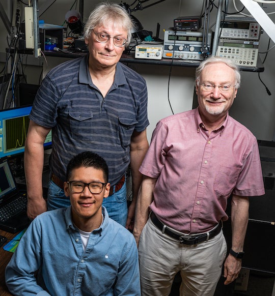 Rice researchers Wei Meng (seated), Sergei Bachilo (left) and Bruce Weisman developed strain-sensing smart skin based on Weisman's pioneering discovery of fluorescence in carbon nanotubes. They worked with Rice structural engineer Satish Nagarajaiah to develop the non-contact method to efficiently measure strain in large structures. Photo by Jeff Fitlow