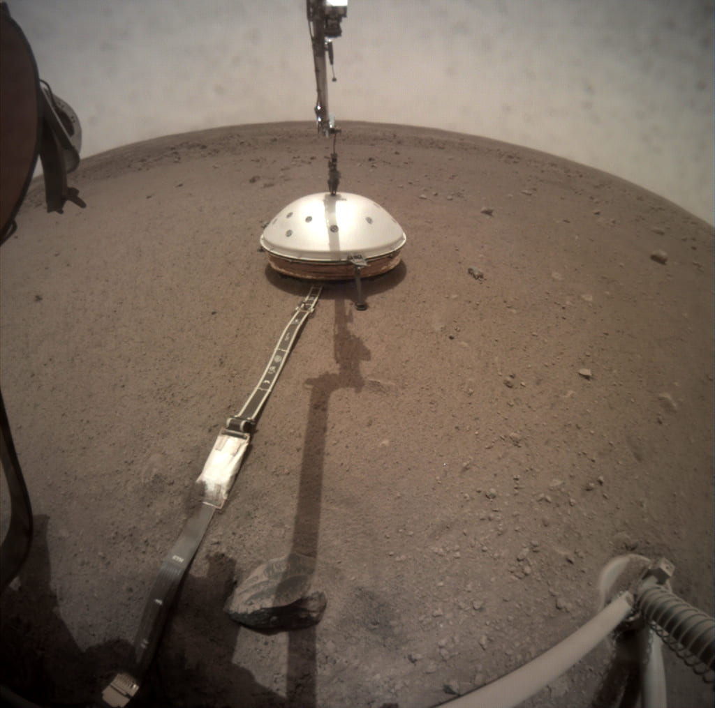 This Feb. 2, 2019 photo shows the robotic arm on NASA's InSight lander deploying a domed cover that shield's the lander's seismometer from wind, dust and extreme temperatures. (Image courtesy of NASA/JPL-Caltech)