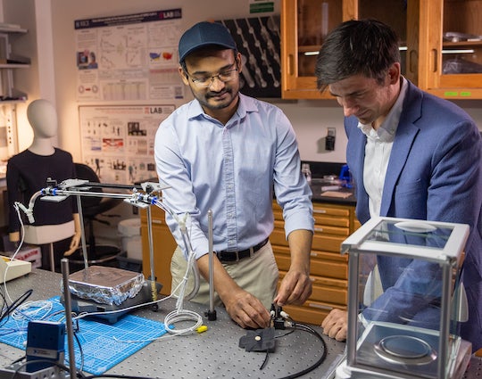 Anoop Rajappan, left, and Daniel Preston of Rice University set up an experiment with their fabric air pump. The lab developed its textile-based energy harvesting shoe able to power assistive devices for people with disabilities. Photo by Brandon Martin