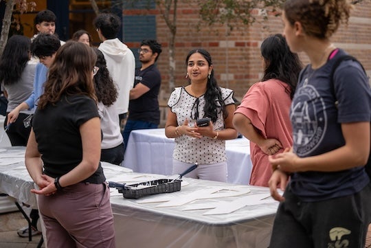 Priyanka Senthil speaks with participants of ALSCI's White Ribbon Build event where participants painted and signed wooden white ribbons for lung cancer patients.