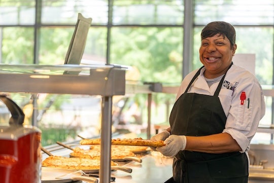 A Rice Housing and Dining employee serves food shortly after Hurricane Beryl rolls through Houston.