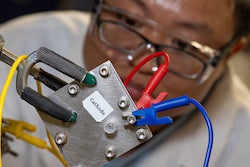 Rice University postdoctoral associate Zhen-Yu Wu sets up an experimental reactor that incorporates a ruthenium-based anode to split water into hydrogen and oxygen without the need for expensive iridium. (Credit: Jeff Fitlow/Rice University)