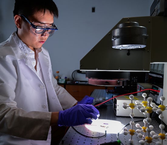 Rice University graduate student Wenbin Li blasts a 2D perovskite solar cell with light in a solar simulator. Rice engineers boosted the efficiency of cells made of two-dimensional perovskites while retaining their toughness. Photo by Jeff Fitlow
