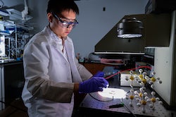 Rice University graduate student Wenbin Li blasts a 2D perovskite solar cell with light in a solar simulator. Rice engineers boosted the efficiency of cells made of two-dimensional perovskites while retaining their toughness. (Credit: Jeff Fitlow/Rice University)