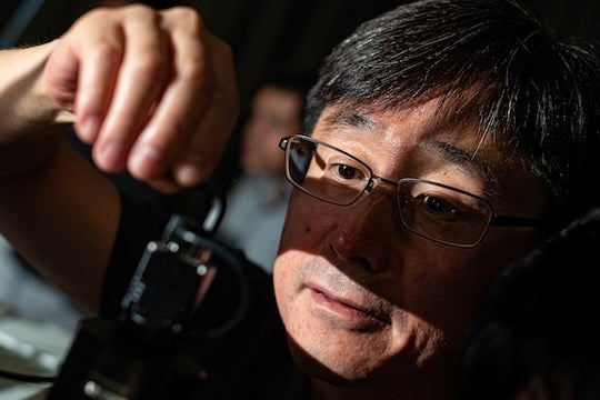 researcher holding an object up and looking at it