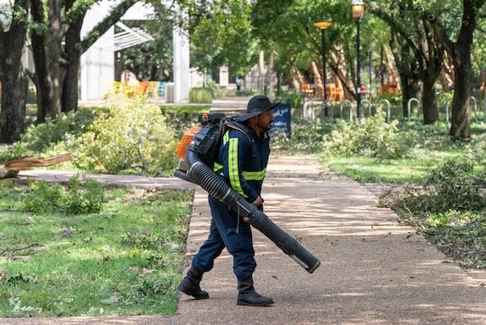 Rice workers clean up debris on campus after Hurricane Beryl.