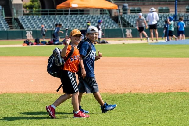Children walking on baseball field. 