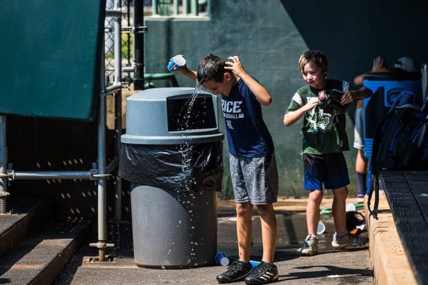 Boy pouring water on head. 