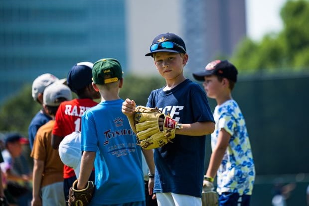 Group of boys, one holding a baseball glove looking into camera 