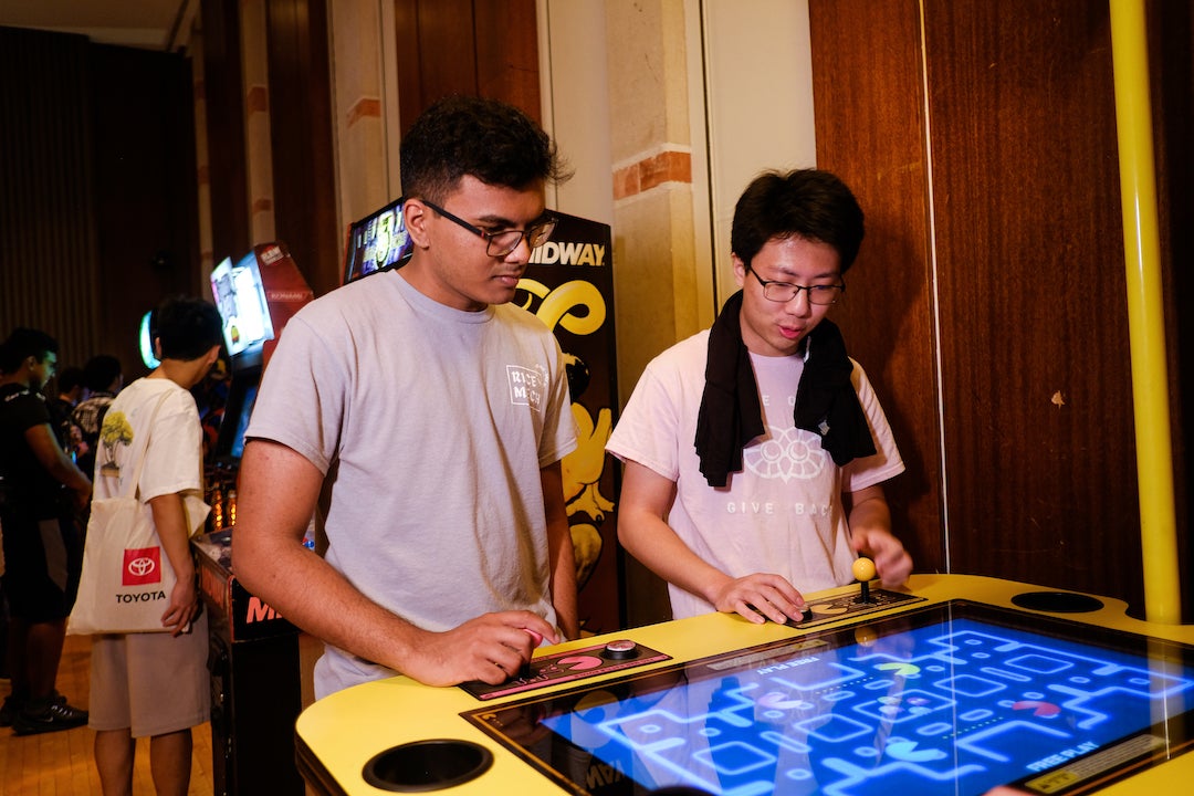 Two students playing Pac-Man video game