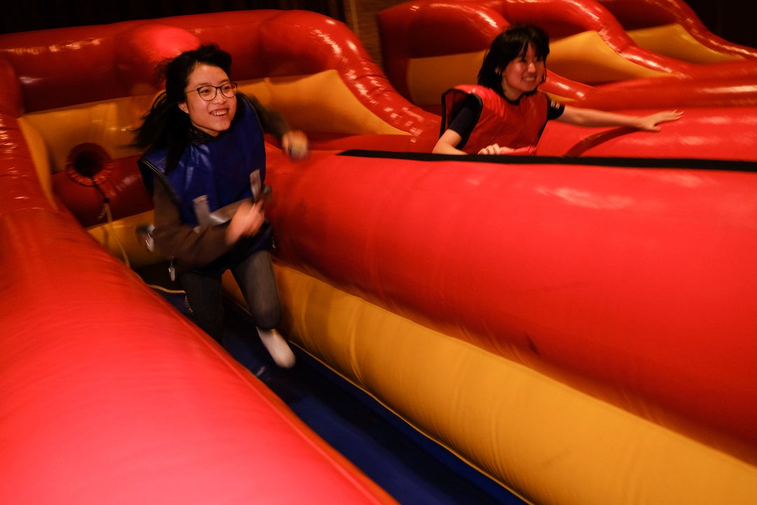 Two students running up inflatable obstacle course