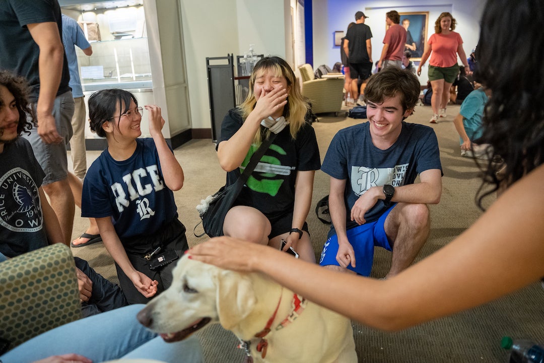 Therapy dog being pet by Rice students at finals study break