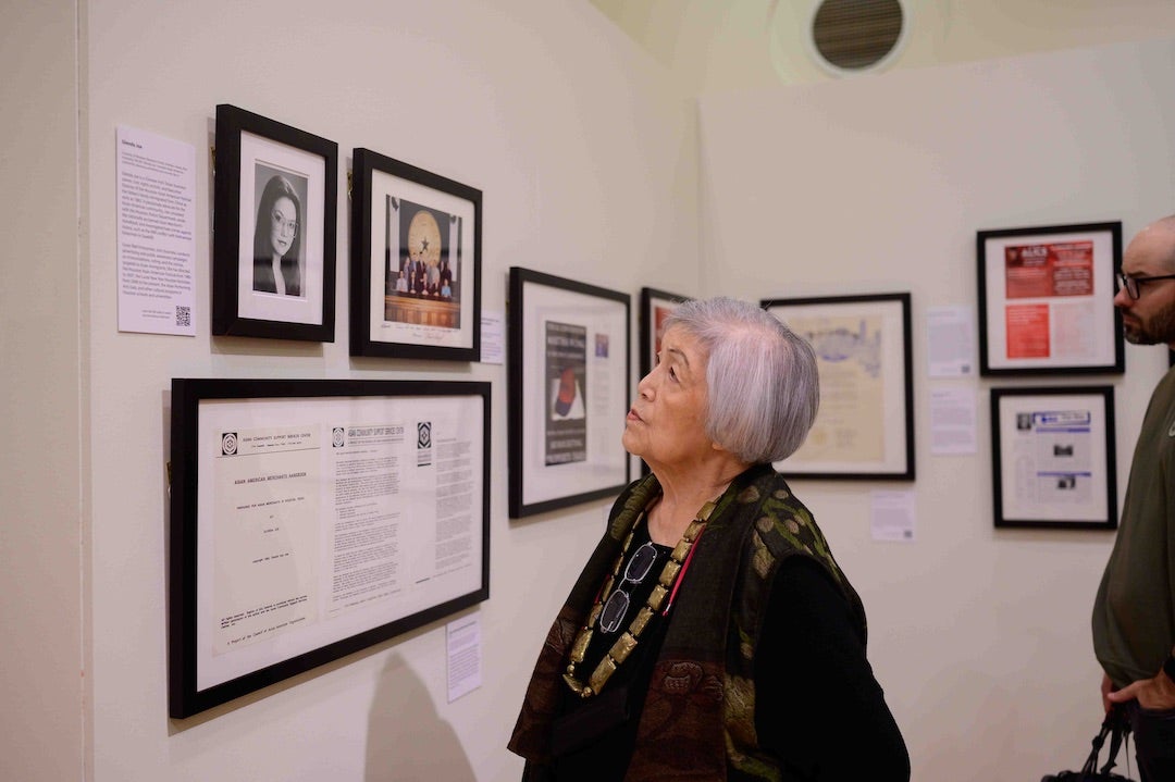 Attendee views items in Houston Asian American Archive exhibition