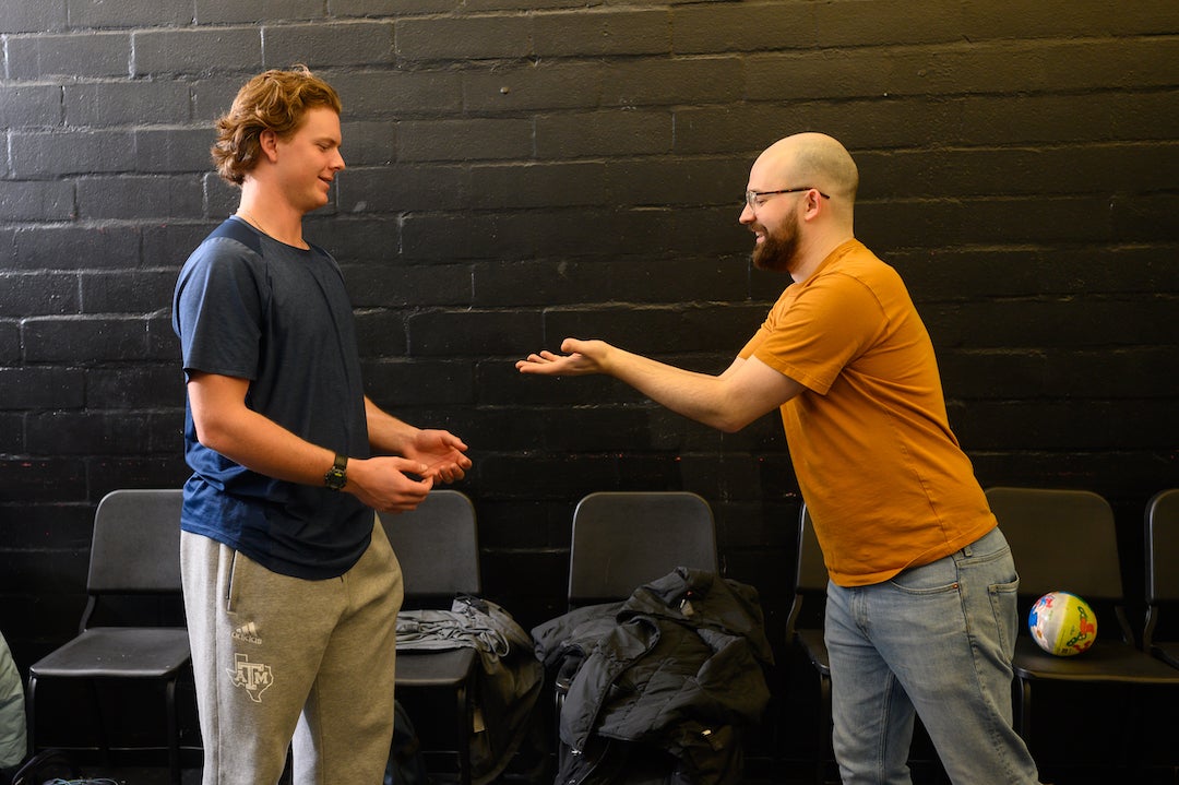 Student on left receives imaginary ball from professional actor on right in acting exercise