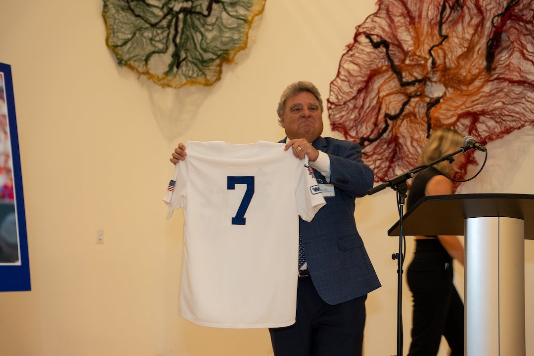 Rice Deputy Athletic Director Rick Mello presents a jersey at the 20-year Rice baseball championship celebration event on March 24.