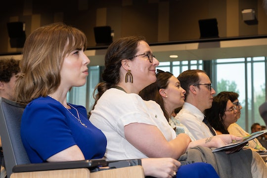 Conference attendees listen closely to a plenary speaker.