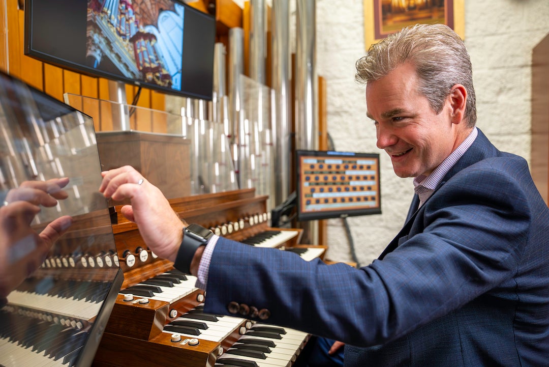 Ken Cowan adjusts the settings of the Houghton-Hauptwerk organ.