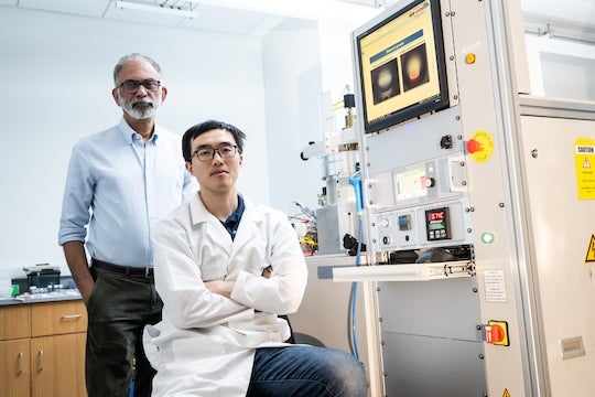 two researchers, one standing and one seated