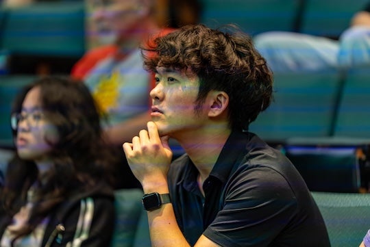 Asian man holding his chin in pensive attitude