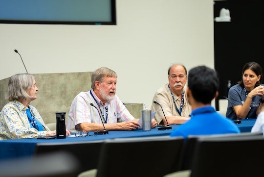 Alumni, including John Spurlino ’88 (center), participate in a panel discussion during the Natural Sciences Undergraduate Research Symposium at Rice University.