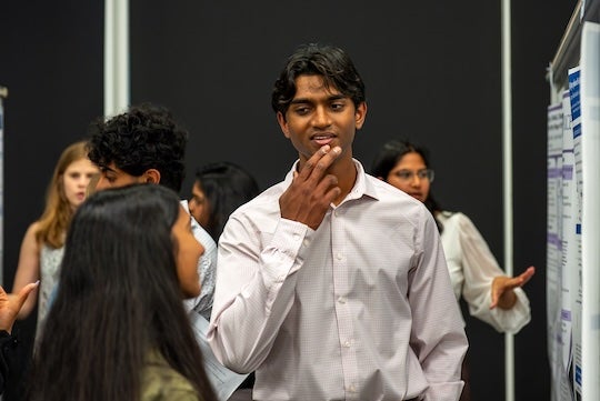 A student presents research to peers and judges during the Natural Sciences Undergraduate Research Symposium at Rice University.