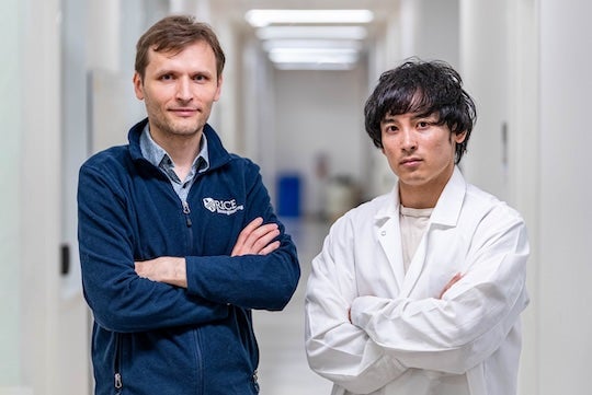 two researchers facing the camera with their arms crossed