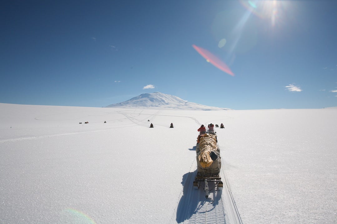 A photo of Fries and her crew loading up a tent and transporting it via sled to Ross Island in Antarctica.