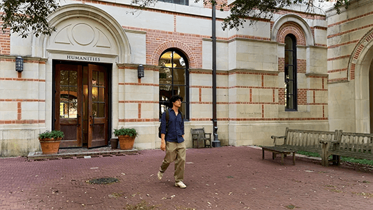 AJ Shin walking outside the Humanities building