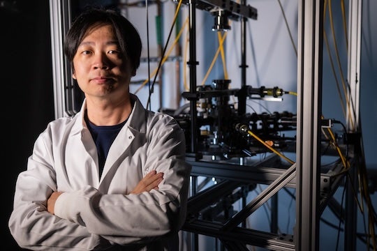 A young Asian man stands in a lab