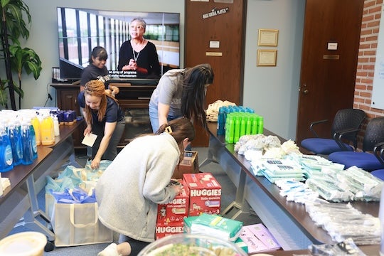 Volunteers from the Department of Psychological Sciences assembling care packages filled with essentials for refugees starting fresh in Houston.