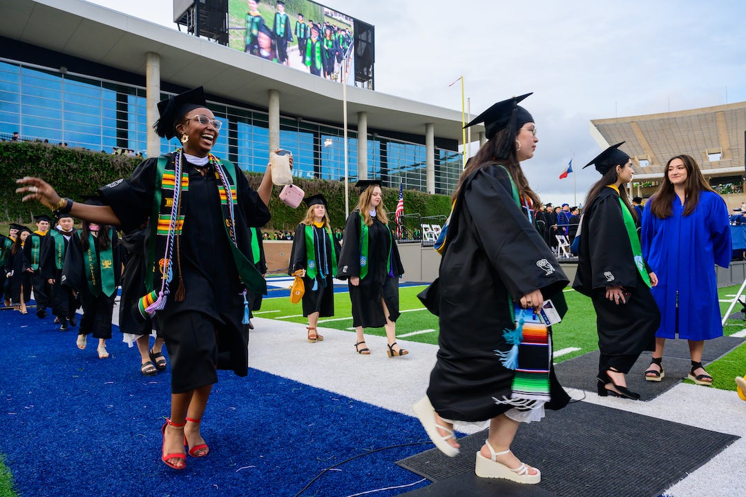 Graduating undergraduates entering Rice Stadium