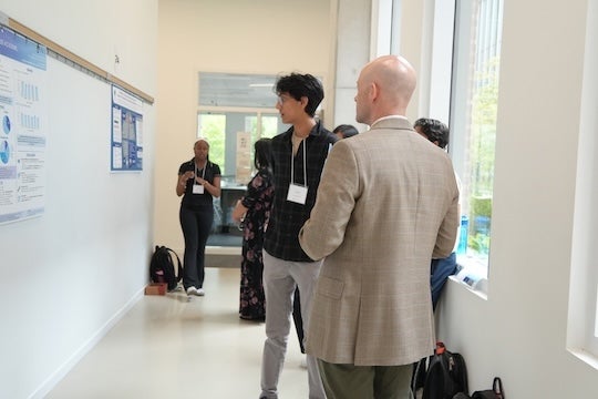 Todd Ferguson, assistant teaching professor of sociology, reviews a student research poster during the Social Sciences Undergraduate Research and Creative Symposium at Rice University.