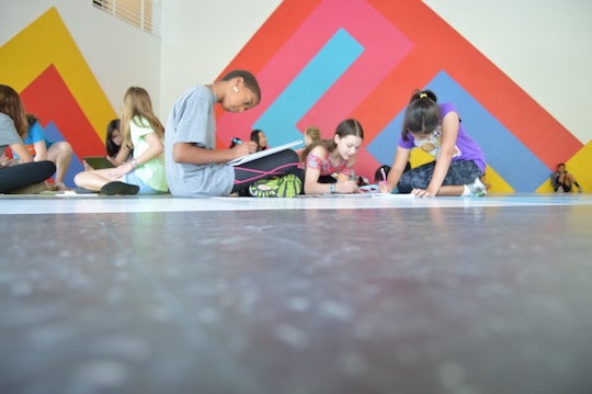 A group of students work on their writing skills during a past Creative Writing Camp.