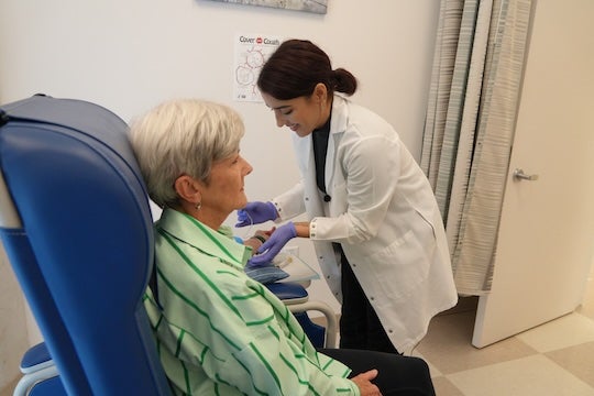 A research team member prepares a participant for a health screening as part of the Project REACH study, which focuses on understanding and supporting the well-being of dementia caregivers.