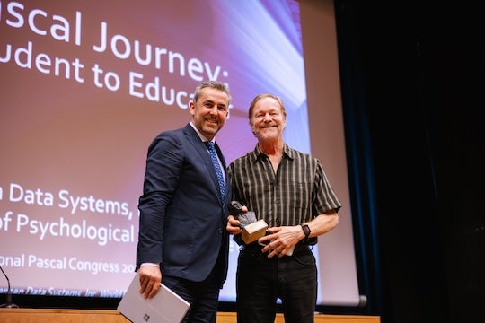 Rice alumnus Cary Jensen, right, receives the Niklaus Wirth Award for Most Valuable Contributor at the International Pascal Congress 2026 in Salamanca, Spain.