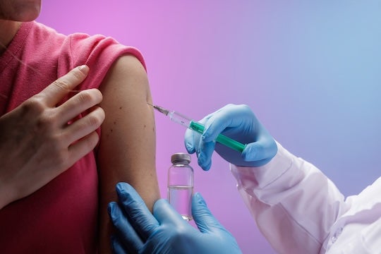 Healthcare working giving patient vaccine. 