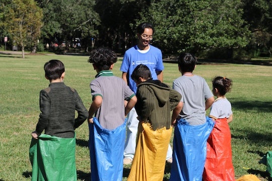 Refugee children enjoy potato sack races.