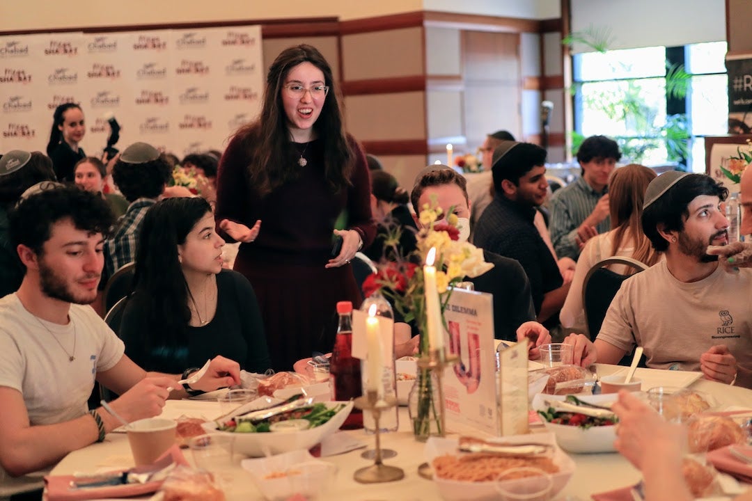Nechama Slonim, co-director of Chabad at Rice, visits with a group of Rice students at a table during Mega Shabbat.