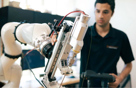 Daniyal Maroufi tests a robotic system (Photo by Emily Kinsolving, Courtesy of Dell Medical School / The University of Texas at Austin). 