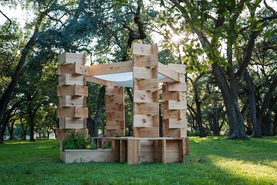 A wooden structure provides sheeting and shade with an unusual Lincoln log type design.