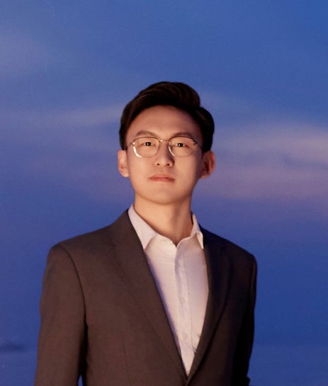 An Asian man in a suit with a serious expression. 