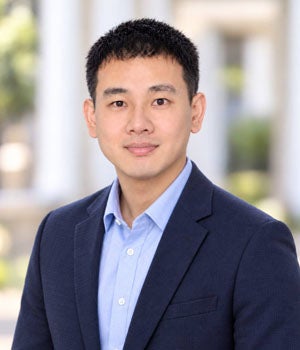 Portrait of Jun-Jie Zhang wearing a suit jacket and collared shirt.