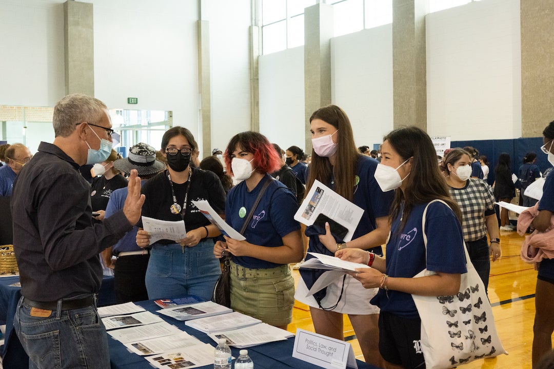 Students visit a booth at academic fair during orientation week