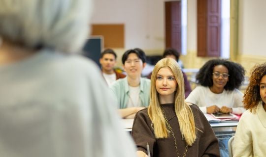 students in classroom facing professor