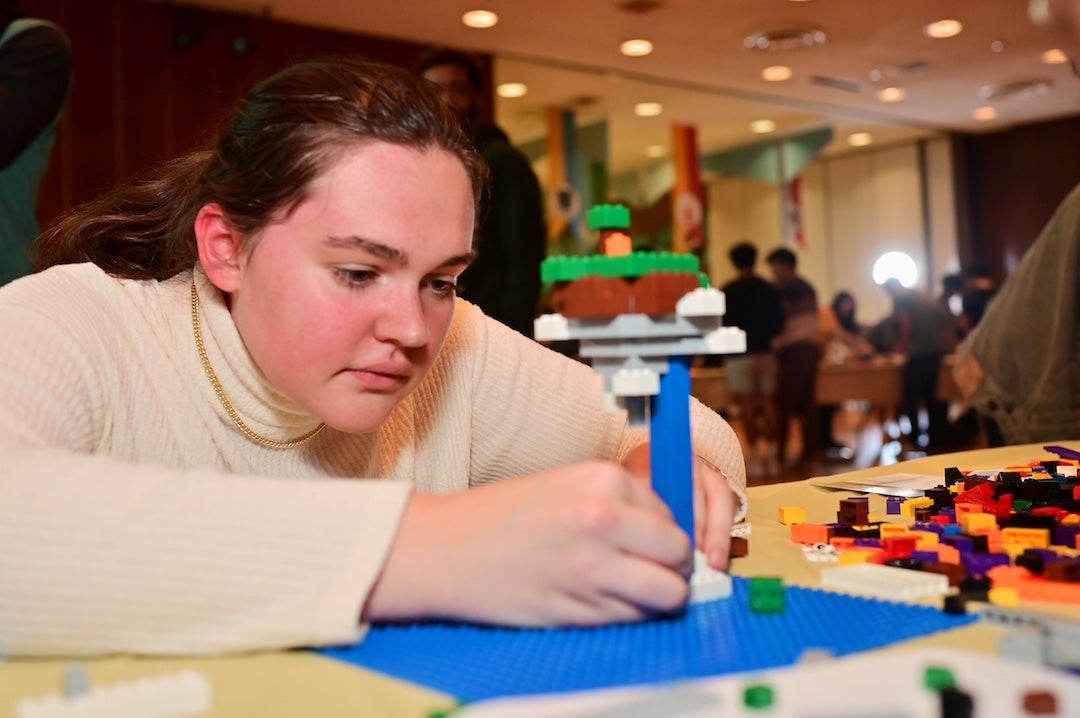 Rice student building Lego model at Owls After Dark event