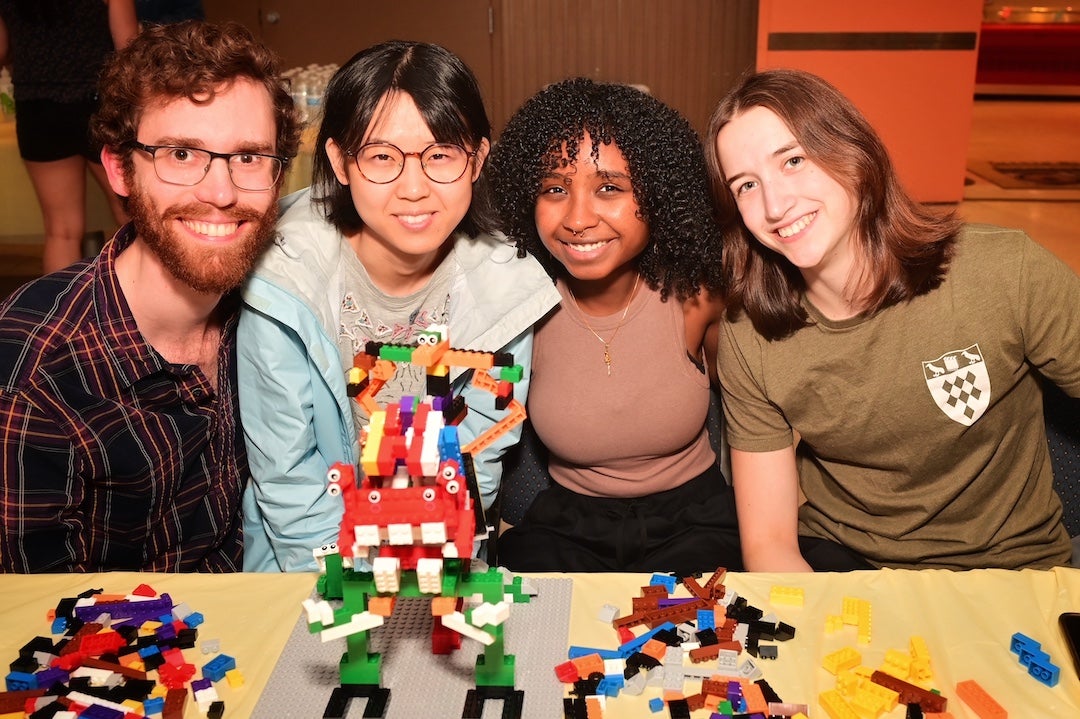 Students posing with Lego creature creation