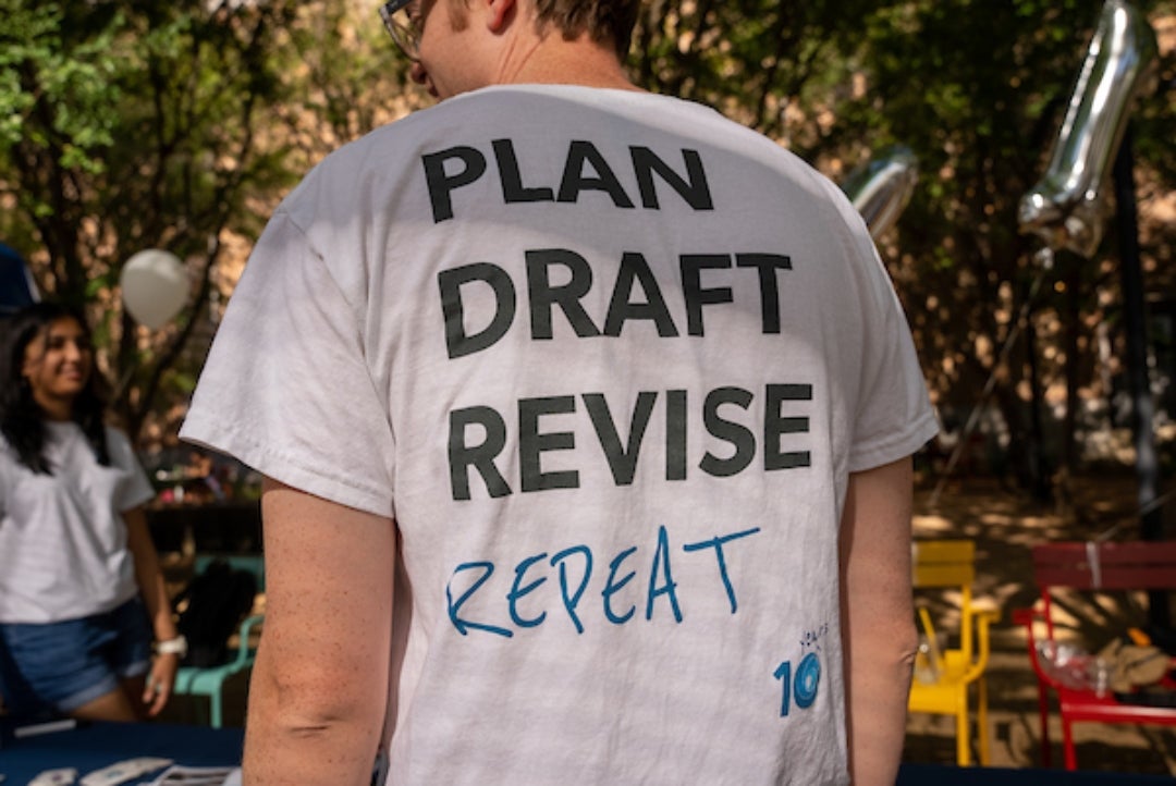Man wearing a t-shirt with plan-draft-revise-repeat written on it